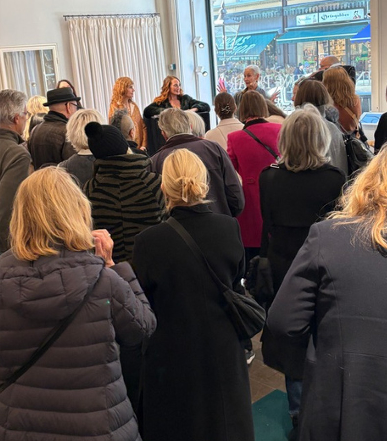 Besökare på Juvelstudion lyssnar på presentation av smyckestillverkare.